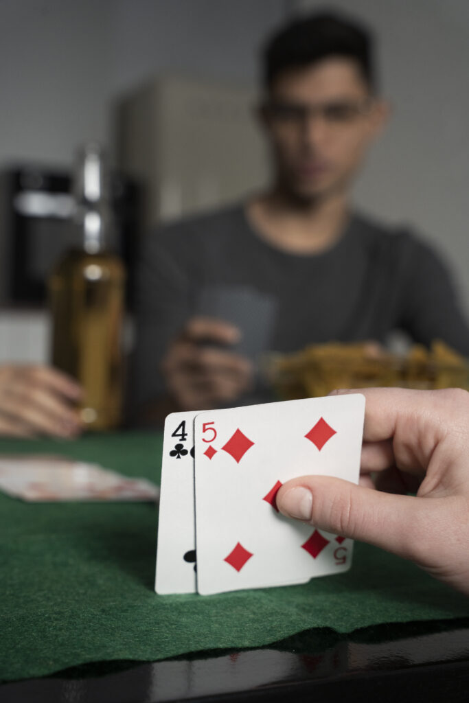 Image d'un joueur de casino misant au black-jack. avec une main de 2 cartes pour atteindre 21, sur une table de poker verte.