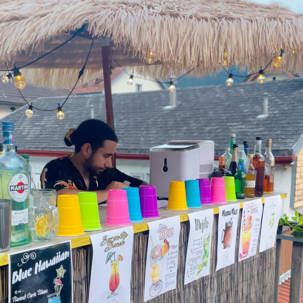 Bar à cocktails avec pailles et parasols hawaïens inclus dans le kit d'animation Hawaï.